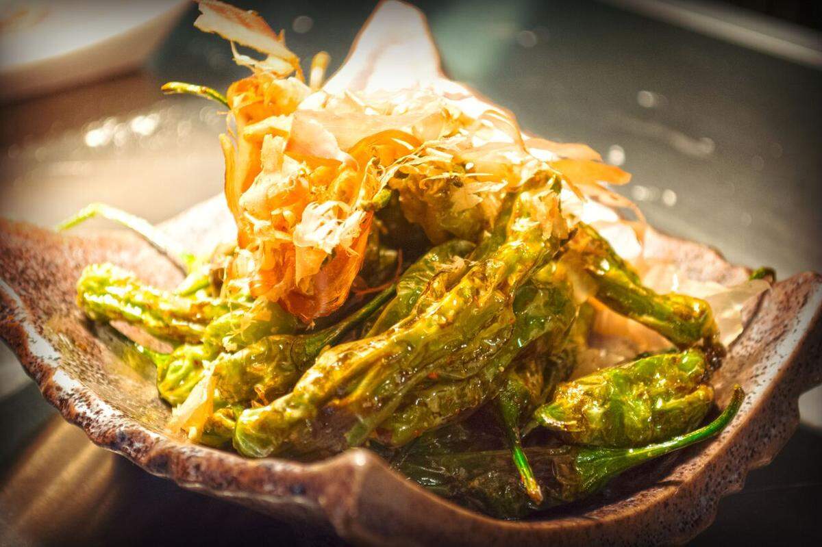 Shishito peppers come sprinkled in bonito flakes that dance with the heat coming off the dish.