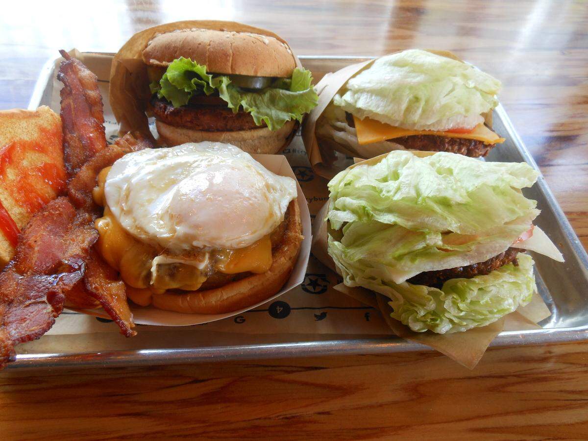 BurgerFi’s standard beef CEO Burger (left) next to their two vegetarian options, the VegeFi veggie patty burger and the Beyond Burger, made from plant proteins. File photo.