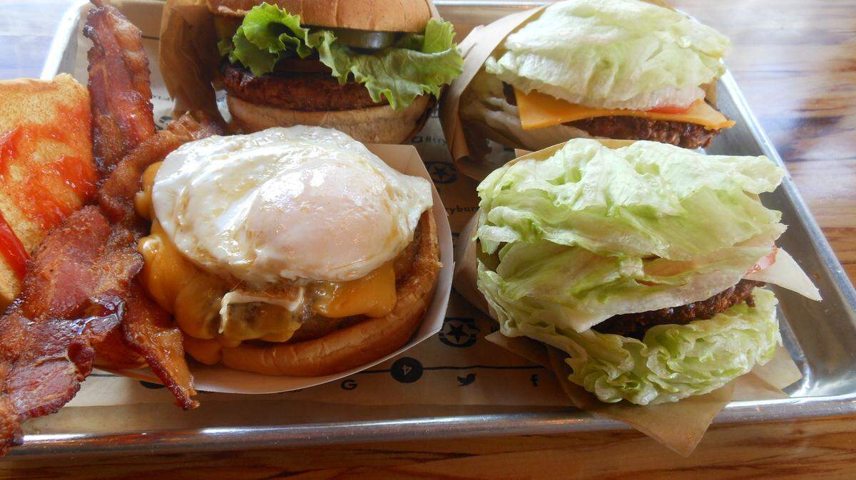 BurgerFi's standard beef CEO Burger (left) next to their two vegetarian options, the VegeFi veggie patty burger and the Beyond Burger, made from plant proteins.