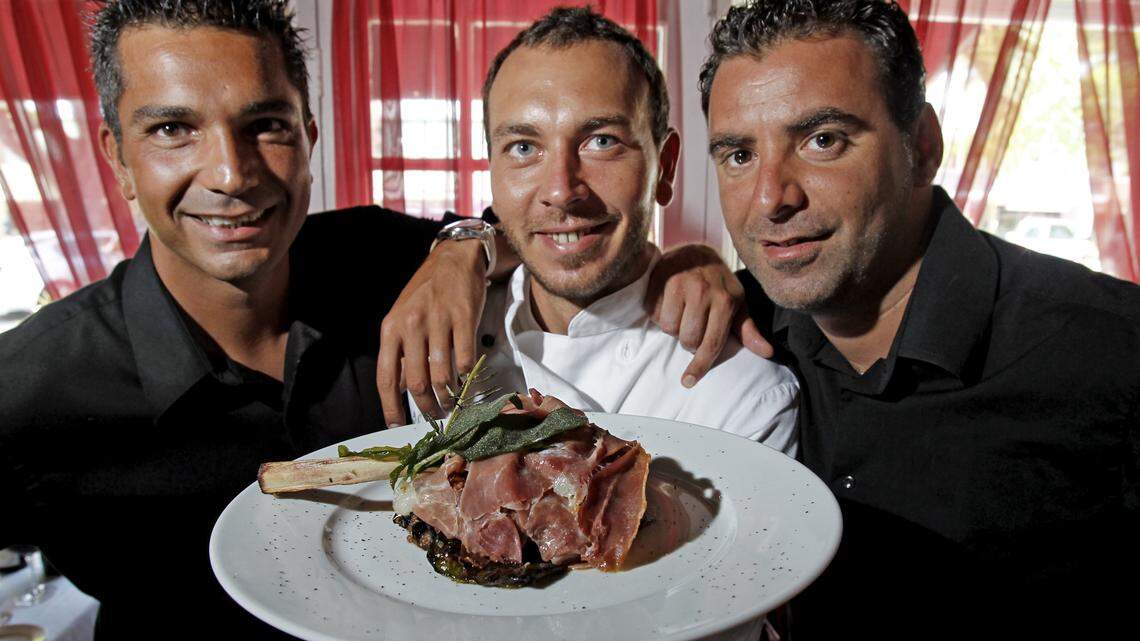FORT LAUDERDALE: Owners Christian D'Amore, left, chef Renato Polidori and Fabio Sabio Bruni show off La Dolce Vita's veal chop prosciutto with sage.