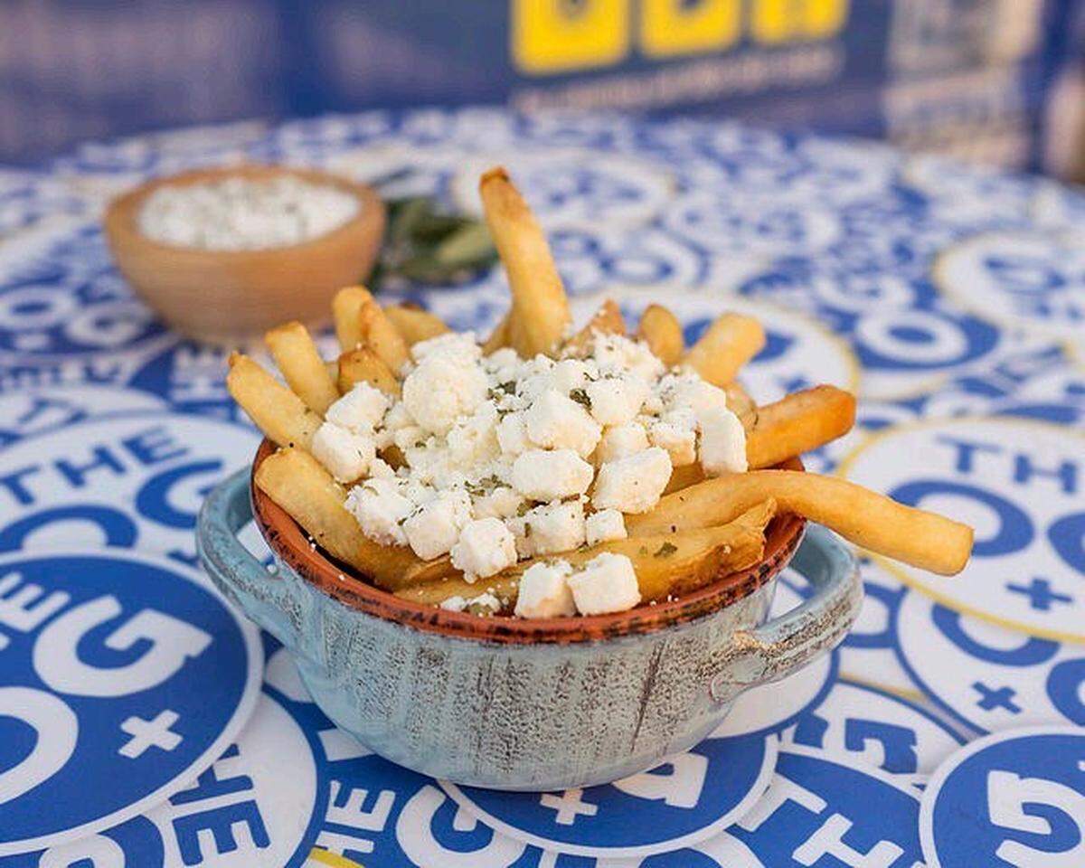 Greek Fries topped with crumbled Feta cheese &amp; Mediterranean oregano. Gluten free, with the skin on and a side of house made tzatziki.