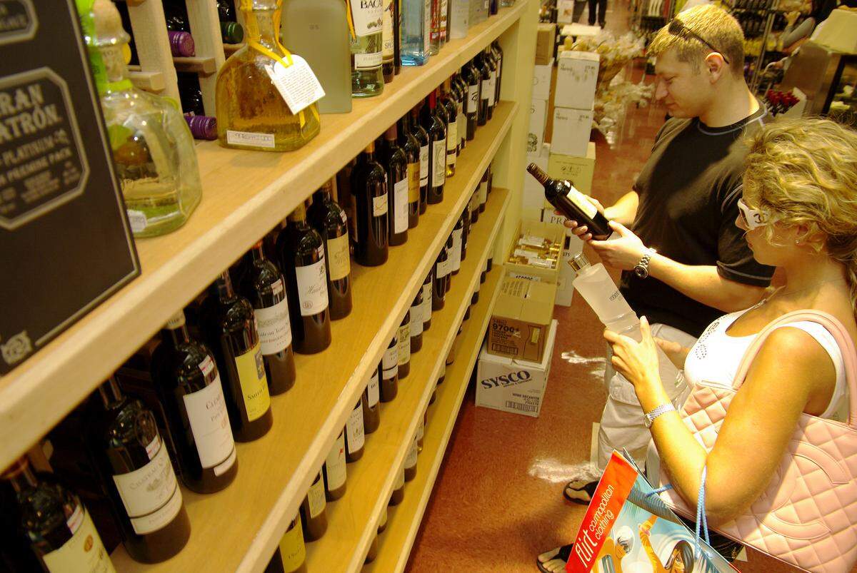 Russian transplants Mariya Manzon, 24, and Steve Manzon, 33, try to decide between wine or vodka at the Epicure Market  - which replaced the landmark Rascal House in Sunny Isles Beach. CHRIS CUTRO / FOR THE MIAMI HERALD.