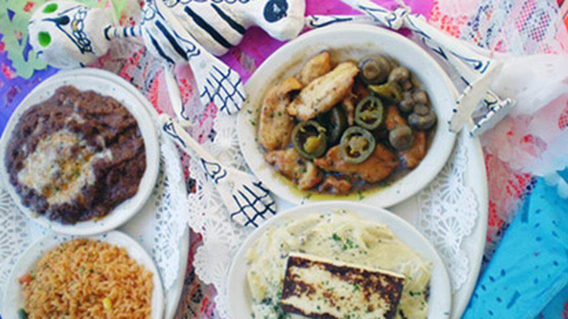 Paquitos Mexican Restaurant in North Miami Beach serves up steak in creamy jalapeno sauce topped with fried cheese and chicken with mushrooms in garlic butter with sides of rice and refried beans year round and for the Day of the Dead celebration November 2nd. Photo: Linda Bladholm.<!-- end forecolor -->