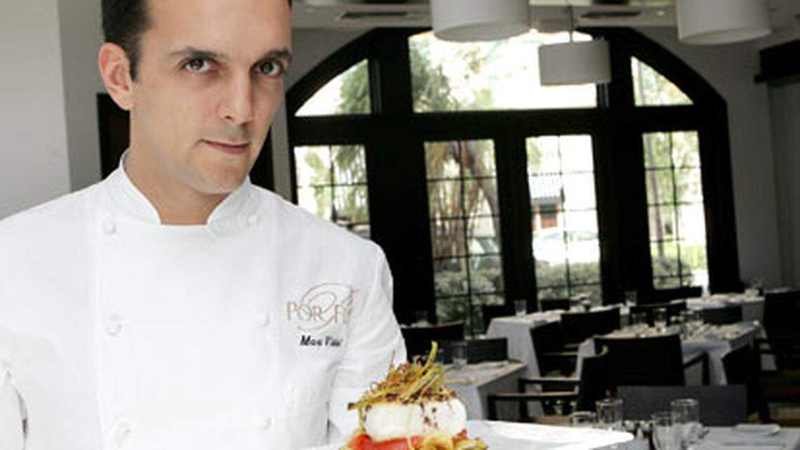 Executive Chef Marc Vidal of Por Fin in Coral Gables holds the Sea Bass: Pan seared and served with potato chips, tomato confit, leek chips, and black olive oil drizzle. Photo: Charlotte Southern.