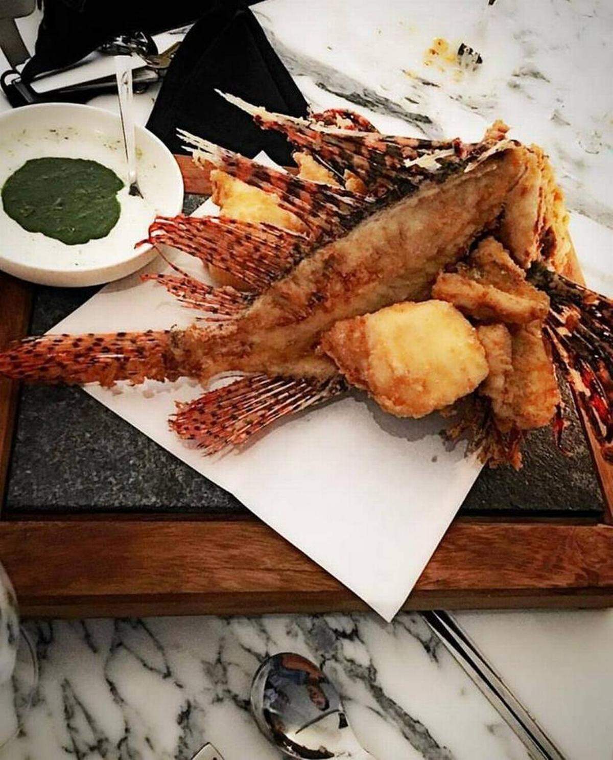 Drama comes on a platter with a whole breaded and fried lion fish, its fan-like fins on full display.