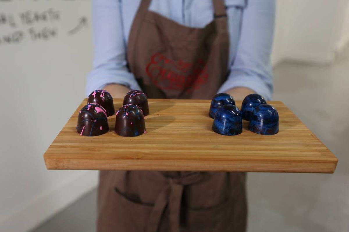Exquisito Chocolates is opening Miami's first chocolate factory in Little Havana. Owner Carolina Quijano displays two different truffles, the Miami Vice (L) and the Guatemalan rum.