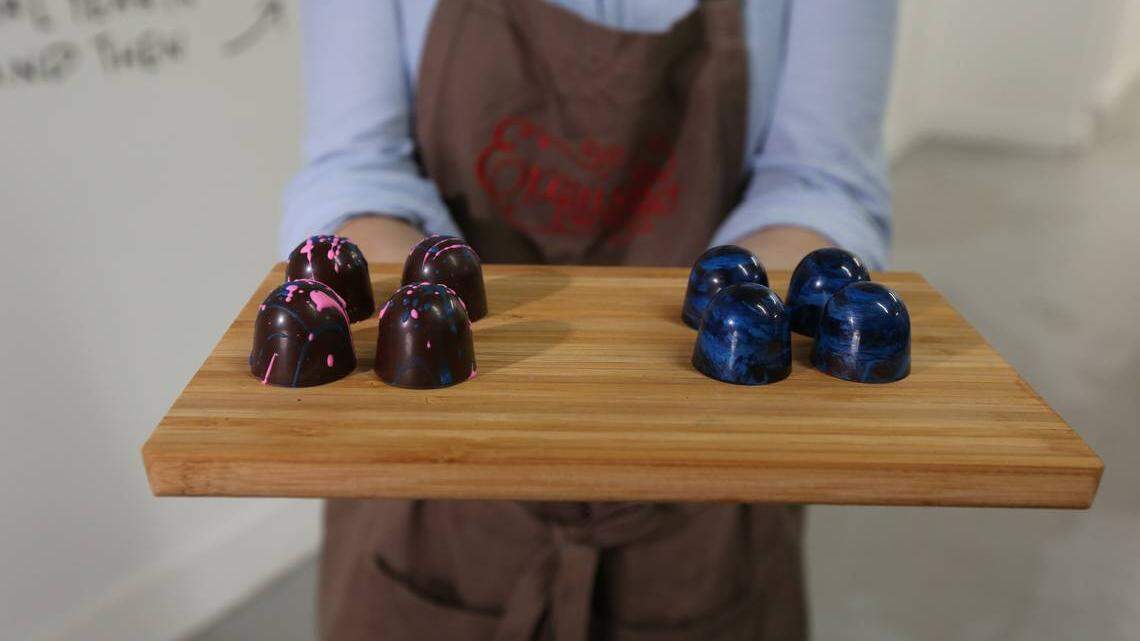 Exquisito Chocolates is opening Miami's first chocolate factory in Little Havana. Owner Carolina Quijano displays two different truffles, the Miami Vice (L) and the Guatemalan rum.
