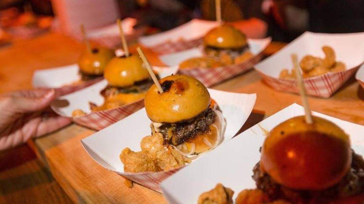 A guest grabs a Guy’s Smokehouse Burger during the 2018 South Beach Wine & Food Festival’s Burger Bash in Miami Beach on Saturday, Feb. 23, 2018.