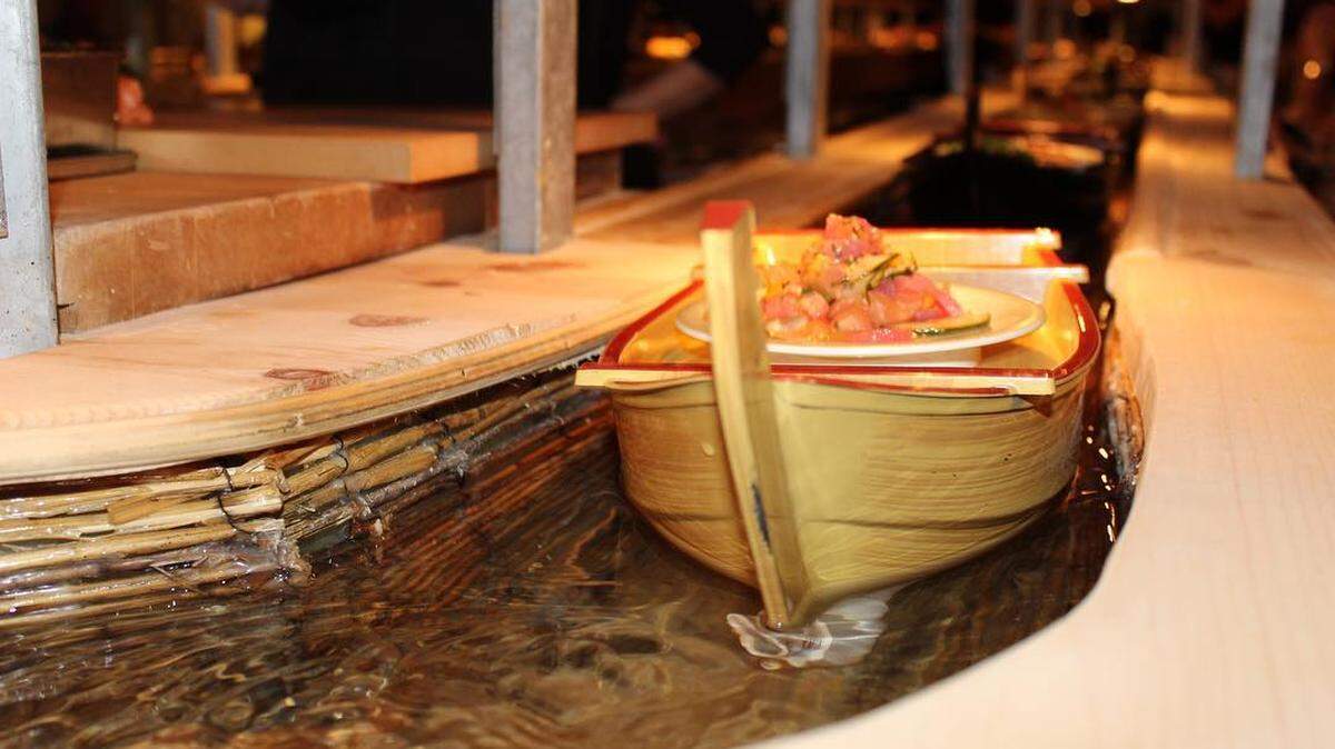 Whimsical boats carry the sushi down the bar at Sushi Lucy in North Miami.