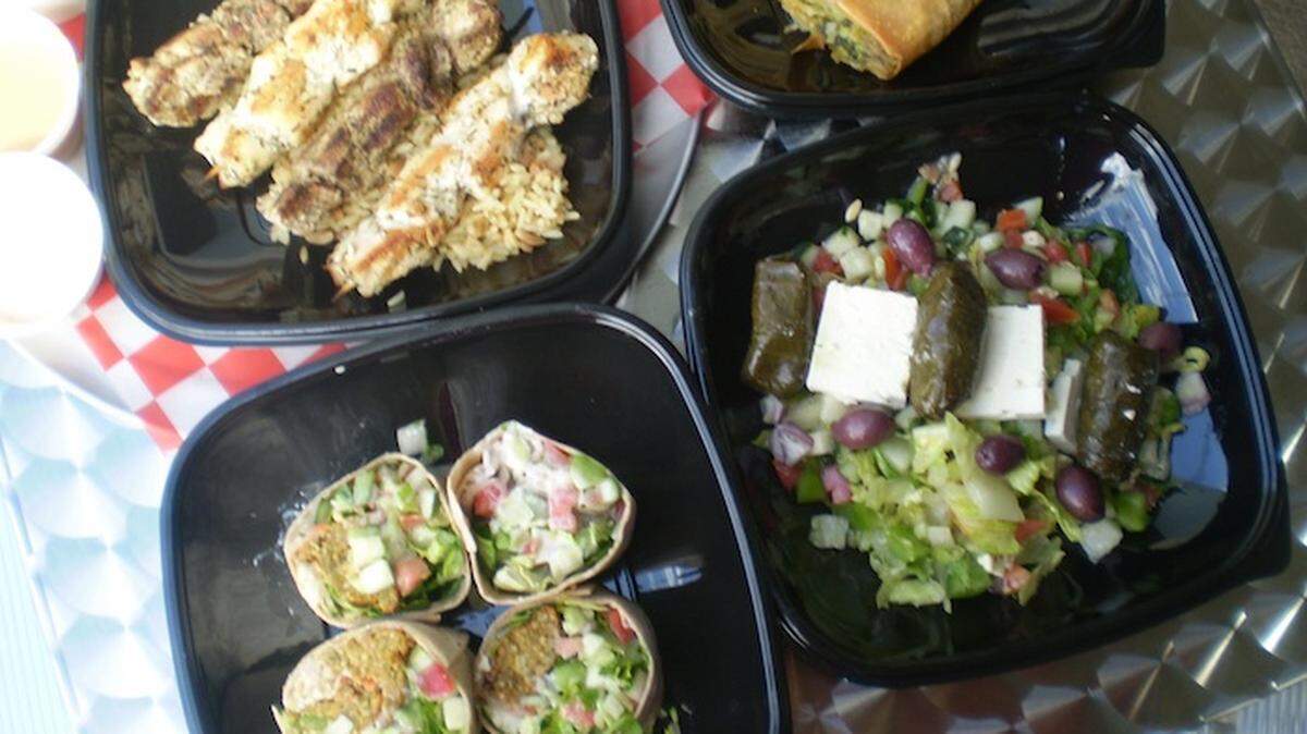 Greek dishes including souvlaki, spinach pie, Greek salad and falafal wrap at Gyroville in Fort Lauderdale.