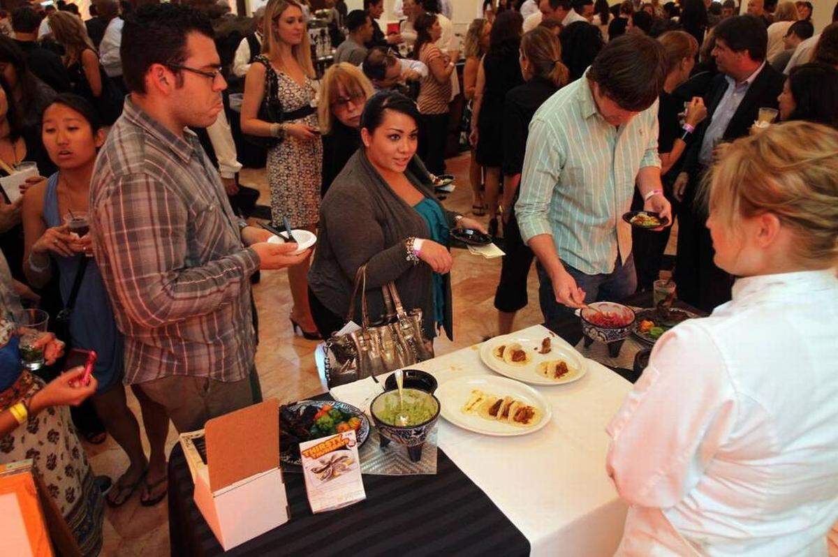 Vanessa Vallejo, in center, asks for a taste of the pork tacos from Jaguar Restaurant during the Taste Of The Gables at the Westin Colonnade in 2011. ALLISON DIAZ Miami Herald File