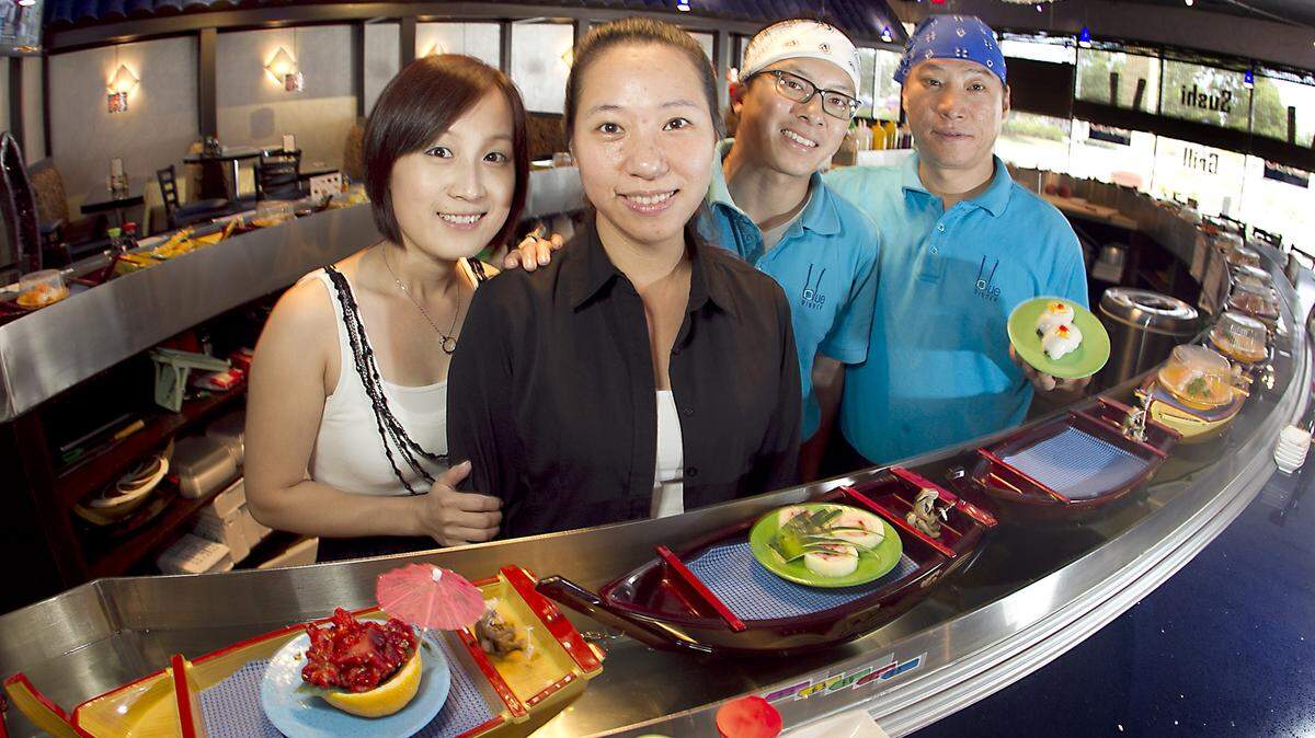 SOUTHWEST RANCHES: Sushi boats float past Blue Ginger hostess Gigi Lin, co-owner Wai Cheng and sushi chefs Richard Tse and Danny Chung.