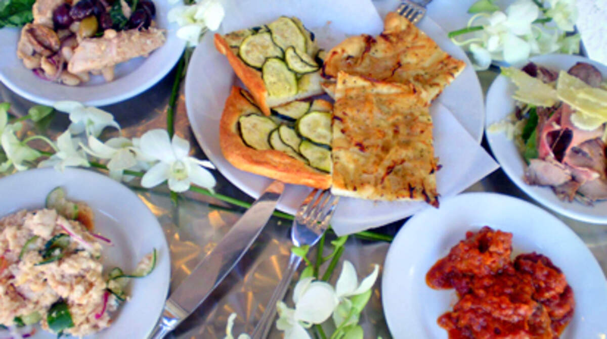 Zucchini and onion focaccia bread surrounded by panzanella, beans and olives and beef with Parmesan served at Mattarello bakery cafe on Miami Beach. Photo: Linda Bladholm.