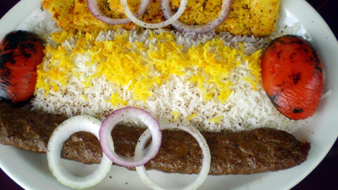 Chicken and ground beef kebabs served with rice and grilled tomatoes at Toarange Persian Cuisine in Coral Gables.