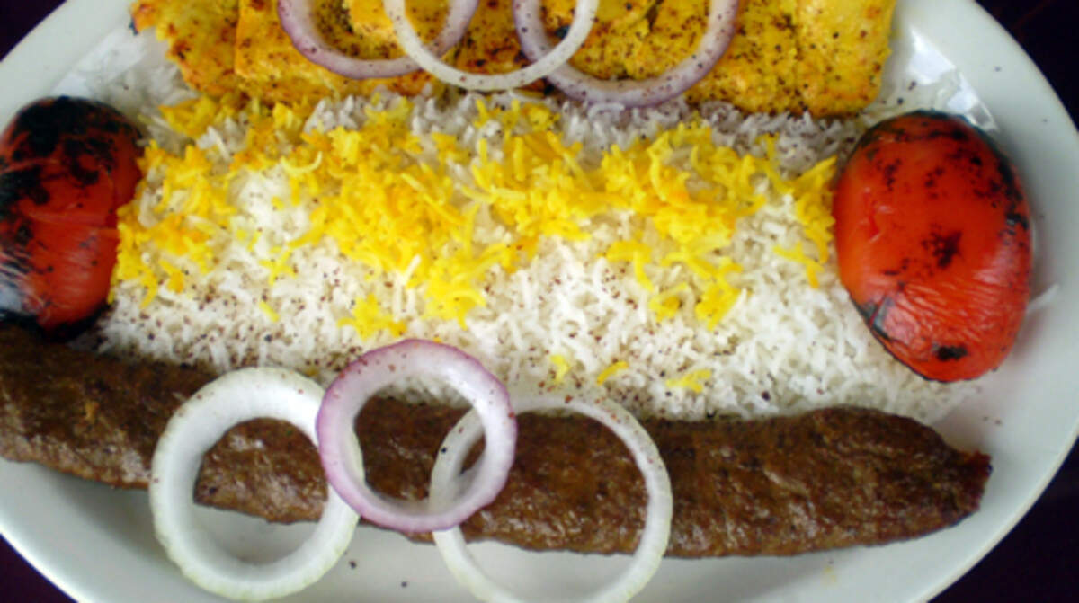 Chicken and ground beef kebabs served with rice and grilled tomatoes at Toarange Persian Cuisine in Coral Gables.