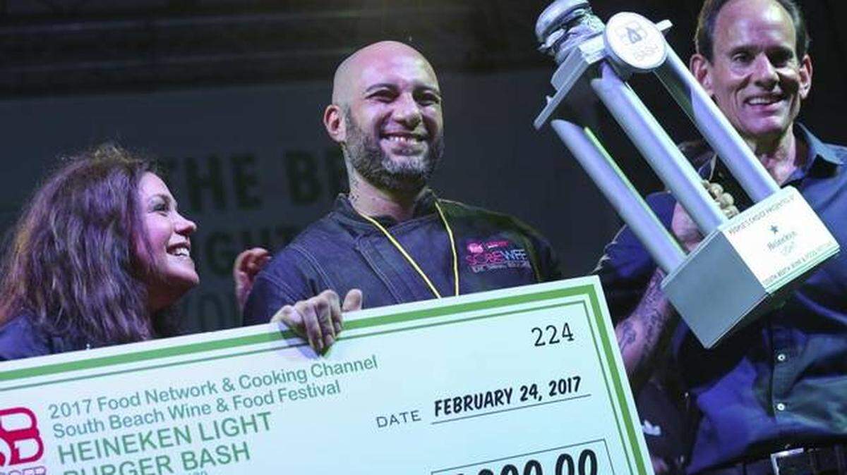 Rachel Ray, left, presents Jr's Gourmet Burgers with the $5,000 People's Choice Award during the Burger Bash at the 2017 South Beach Wine & Food Festival on Friday, Feb. 25, 2017.