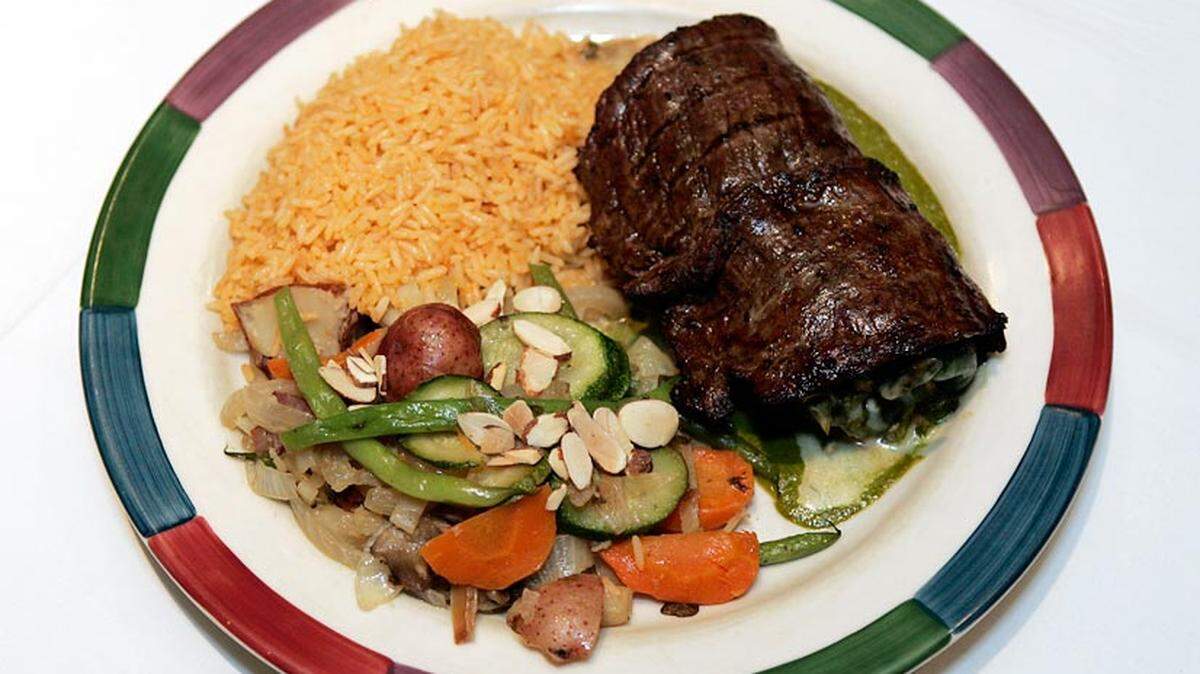 Sauteed shrimp, mushrooms, onions and monterey jack inside a poblano pepper wrapped in a carne asada steak on a bed of chimichurri sauce at Gourmet Mexican food restaurant Cantina Laredo in Plantation.