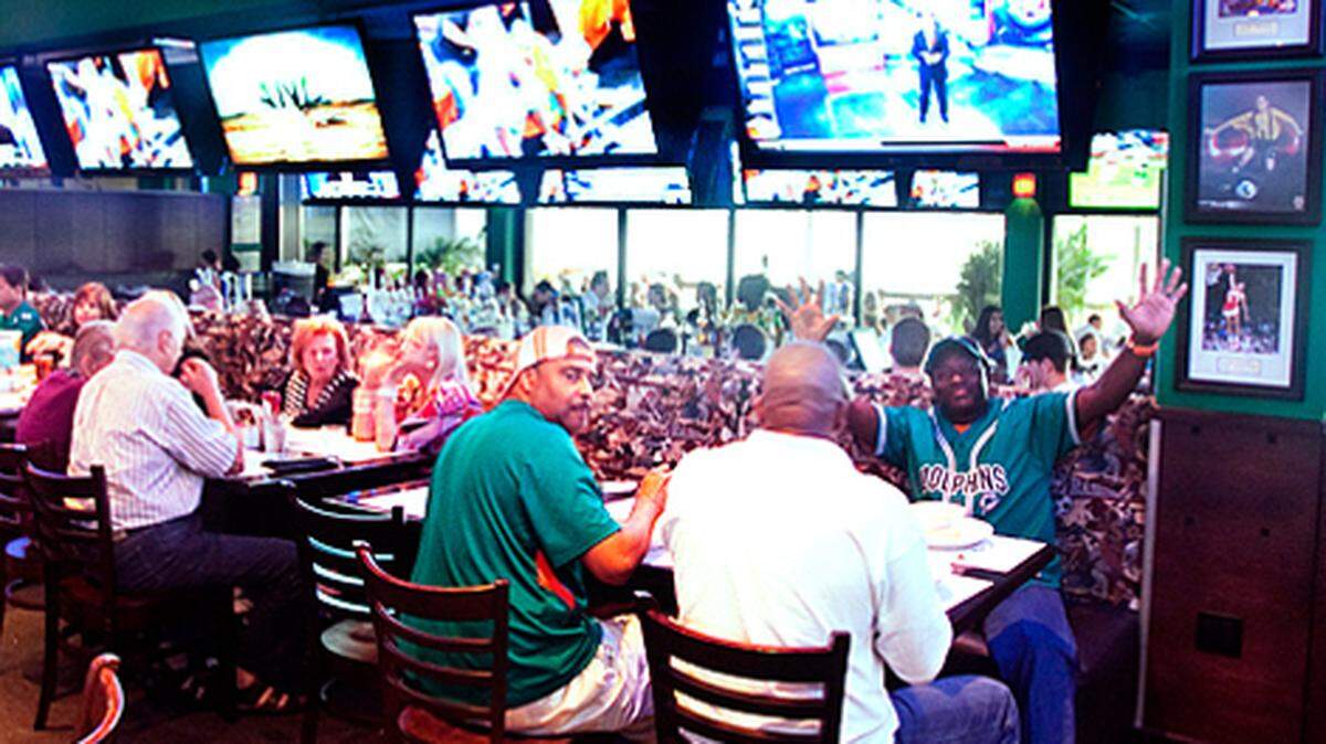 Miami Dolphins fans watch a preseason game at the Duffy’s Sports Grill in North MIami Beach.