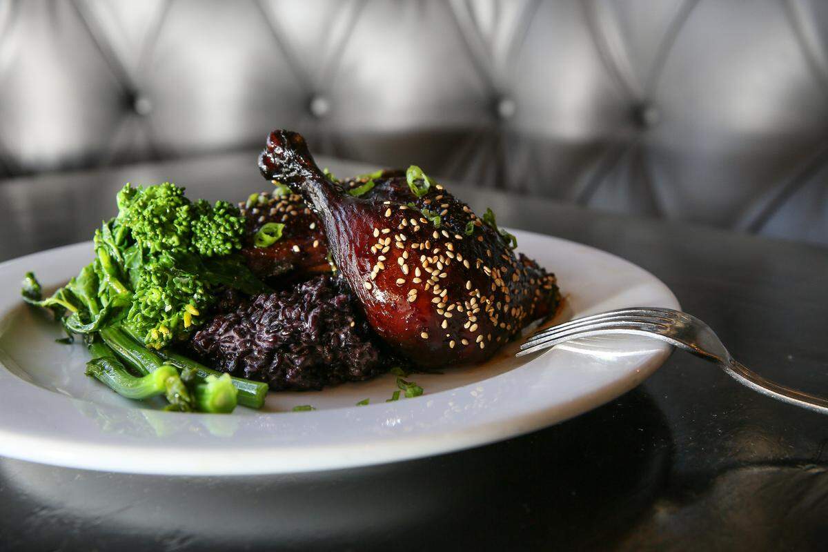 Korean barbecued half chicken with purple sticky rice and rapini.
