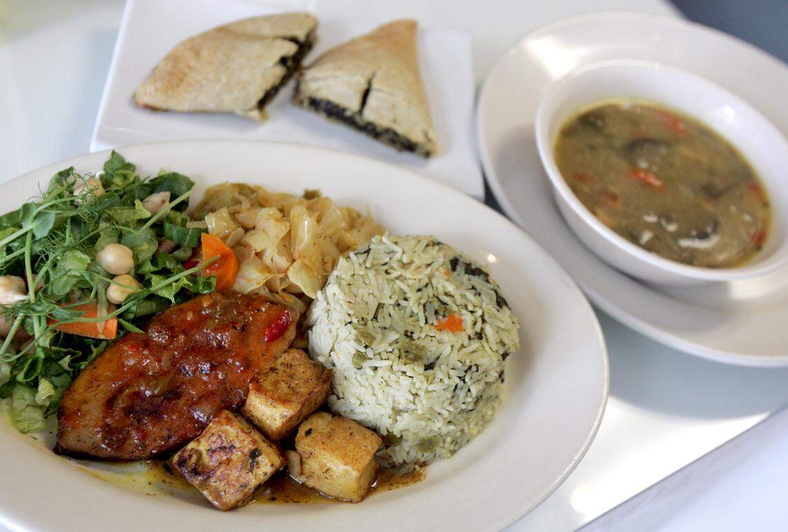 The Souper Incredible at The Vegetarian Restaurant by Hakin in North Miami Beach. Clockwise on plate: Caribbean Garden Salad, steamed cabbage with carrots and bell peppers, seasoned rice with vegetables and spinach, herb tofu, and veggie fish. In the background is the spinach patty and garden soup. (Everything is standard with the meal except for the soup which varies daily.) (1 of 1)