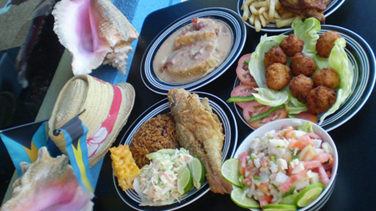 Clockwise from the back, guava duff, fried chicken, conch fritters, conch salad and fried snapper with rice and peas, mac and cheese and coleslaw at Lynn's Bahamian Kitchen, West Park.