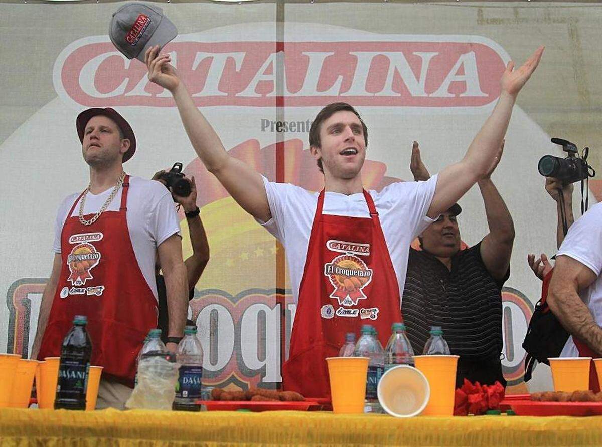 Carmen Cincotti lifts his arms in victory after eating 158 croquetas to win the World Championship Croqueta Eating Contest presented by Catalina at the El Croquetazo event during Calle Ocho on Sunday, March 12, 2017.