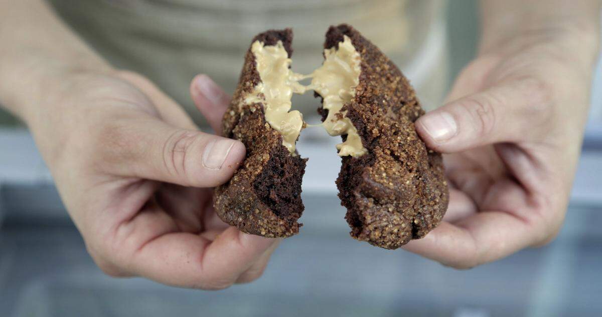 Devin Braddock breaks molten fudge cookie in half.