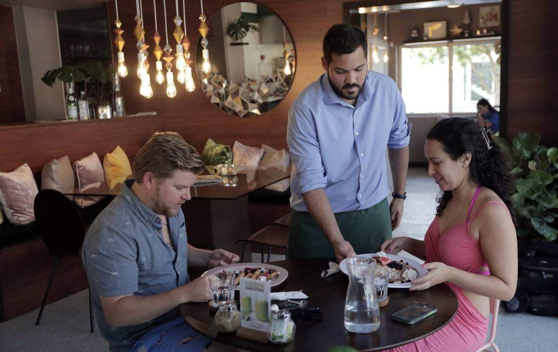 Ivan Nieves, center, serves customers at La Social Restaurant in Miami on Thursday, July 26.