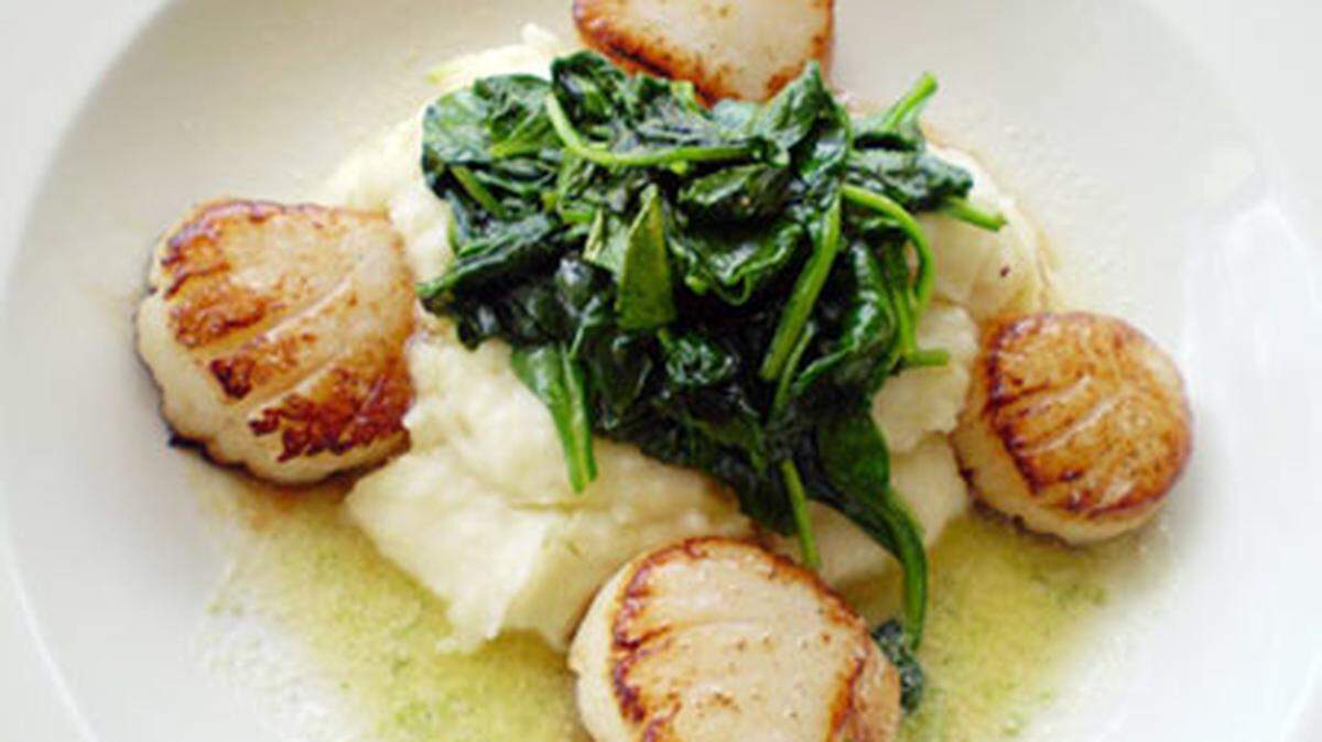 Seared scallops with mashed potatoes and wilted spinach pooled in lime butter as served at Buena Vista Bistro. Photo: Linda Bladholm.