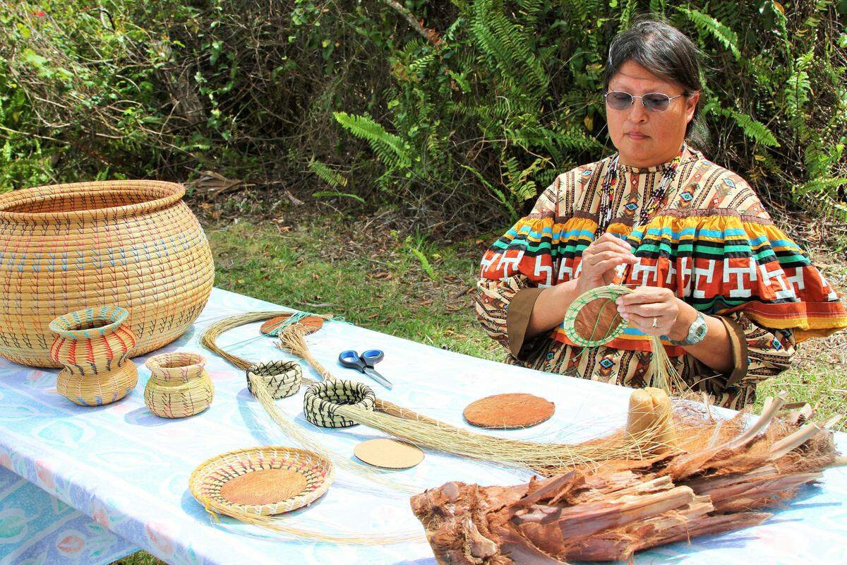 Donna Billie Kolobziej, who teaches students basket weaving at the Miccosukee Indian School, shows guests the “dying art” of weaving baskets from sweetgrass and palmetto husk.