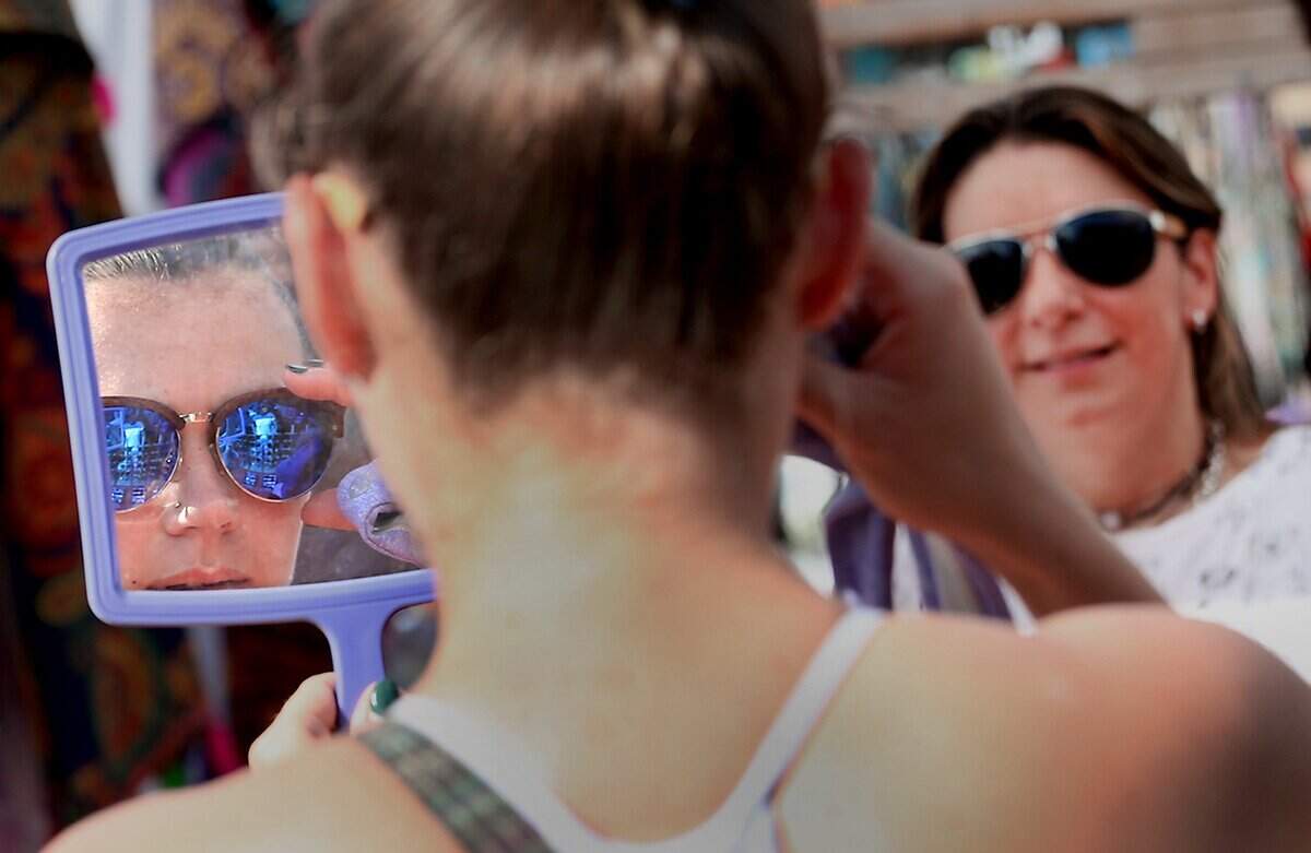 Dana Wall of Miami tries on glasses made by  Paola Lina (background) of OK4U a shoppers attend the very last Miami Flea of 2016  put on in the Arts + Entertainment District in Miami on Sunday, December 18, 2016