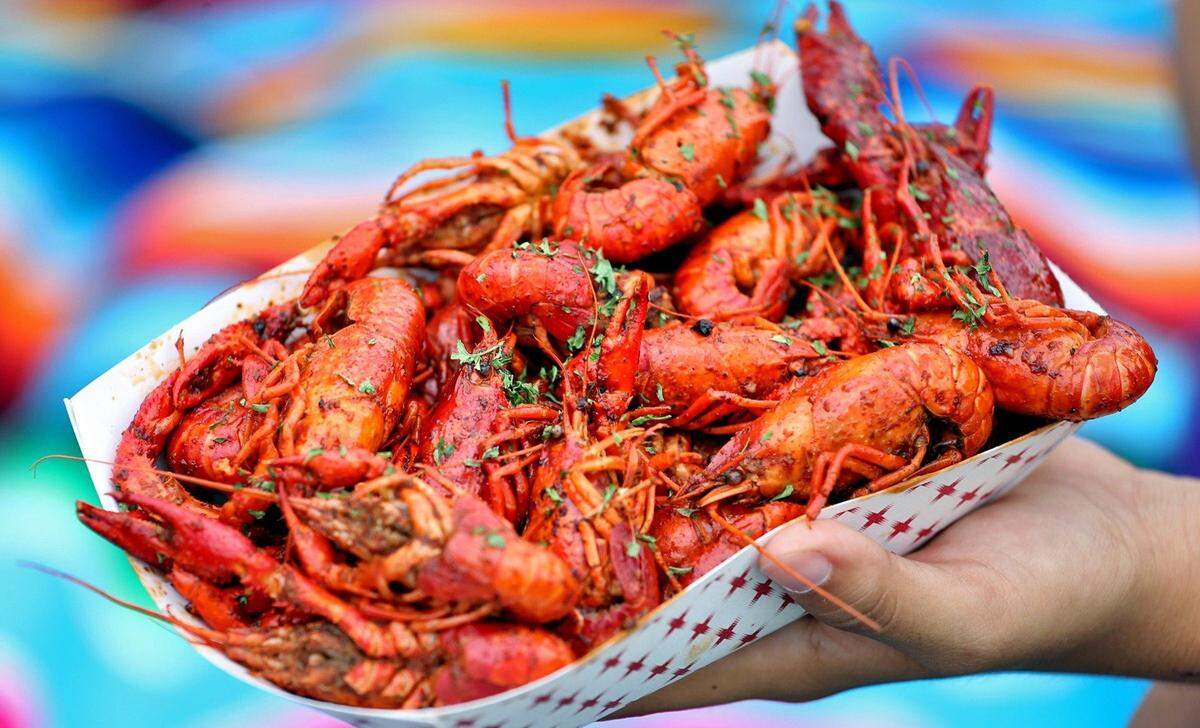A customer sits with a plate of crawfish at the 12th Annual Deering Seafood Festival on the Bay on Sunday, March 20, 2016