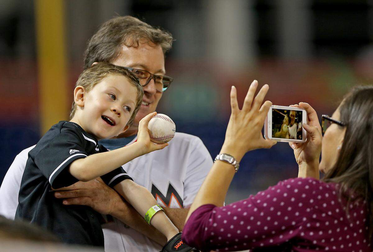 Tom Zur holds his 4-year-old son Tom as mom Jennifer Zur shoots their picture as the Miami Marlins host the Tampa Bay Rays on Monday, May 1, 2017 at Marlins Park in Miami, Fla. (Patrick Farrell/Miami Herald/TNS)