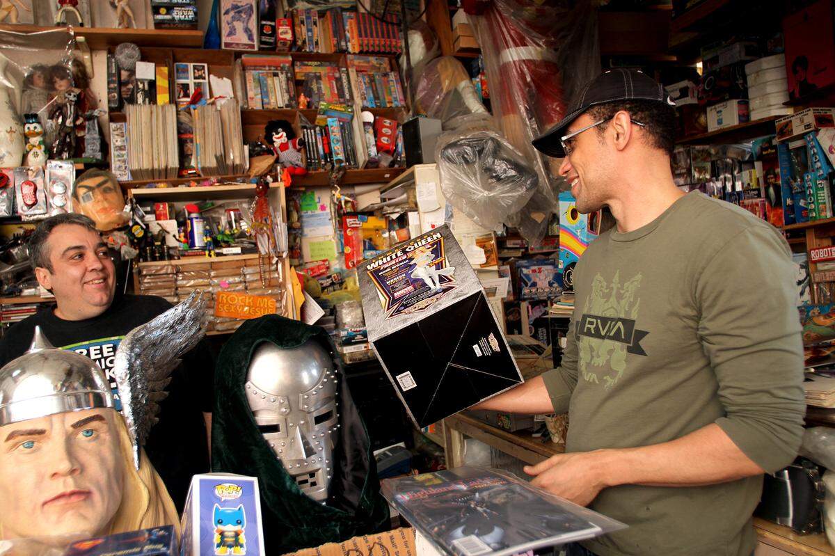 Store owner Jorge Perez makes a deal with regular customer Allen Cuvilly at A&M Comics and Books in this photo taken on March 11, 2011.