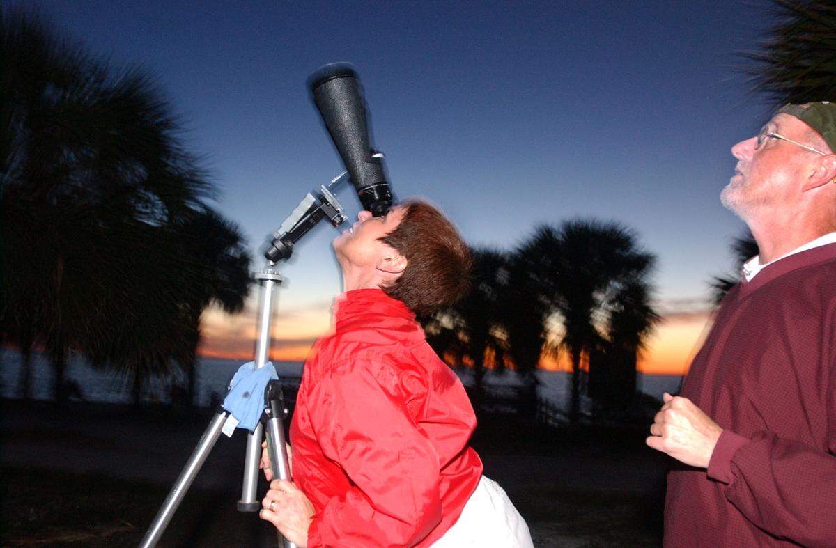 01/10/03--MARICE COHN BAND/MIAMI HERALD STAFF--KEY BISCAYNE; Tropical Star Party, a gathering to watch the winter sunset and stargaze, was held at Bill Baggs Cape Florida State Park, on Key Biscayne, Friday. High-tech equipment was set up to see the first-quarter moon, winter constellations, Saturn and Jupiter. Key Biscayners Meghan Halley (cq) and her husband Tom, on the right, took a look at the moon through a pair of binoculars set up by Barb (cq) Yager, one of the directors of Southern Cross Astronomical Society.  DADE (1 of 2)