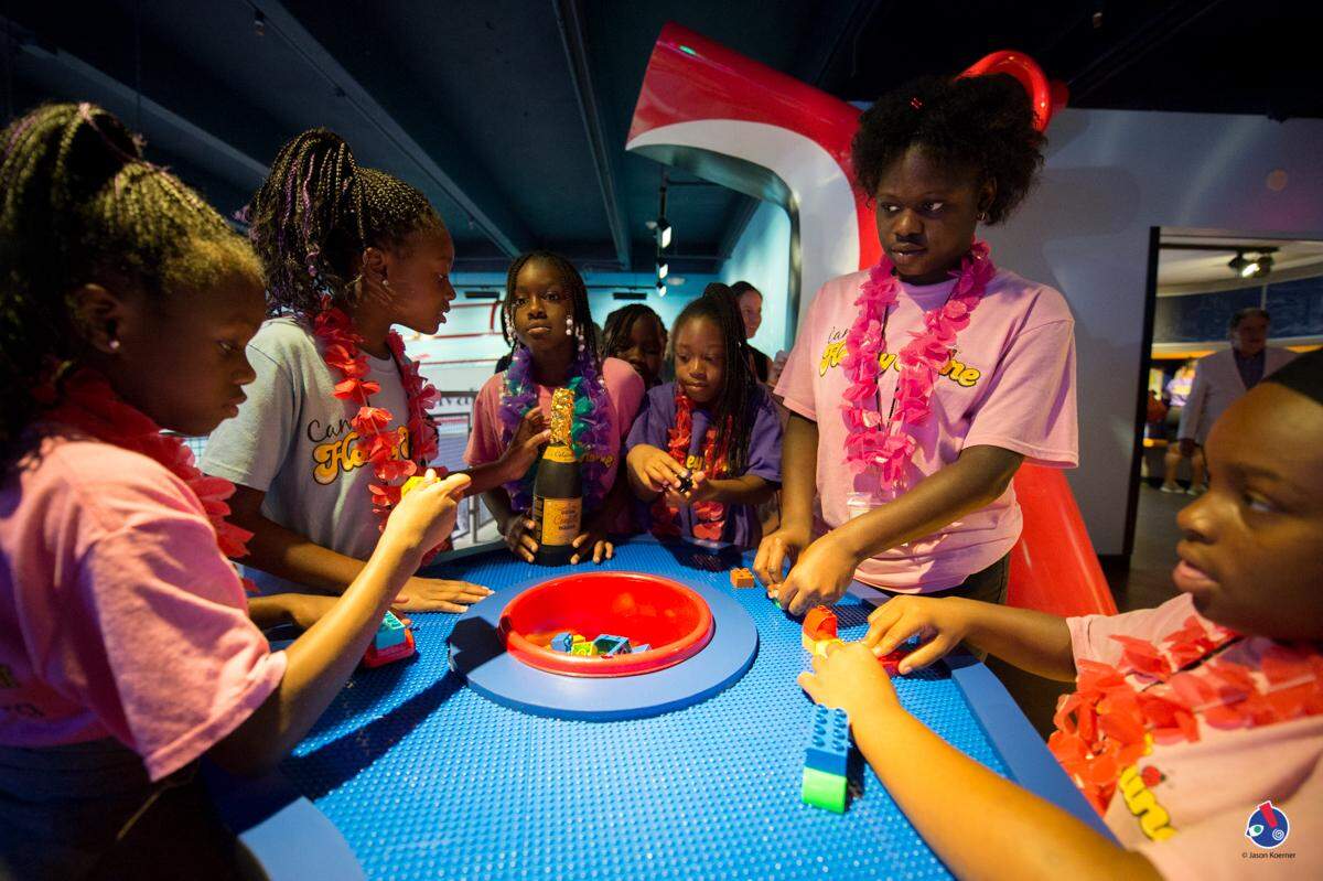 Girls from the Honeyshine Program get creative at the Lego Table. Photo by Jason Koerner Photography.