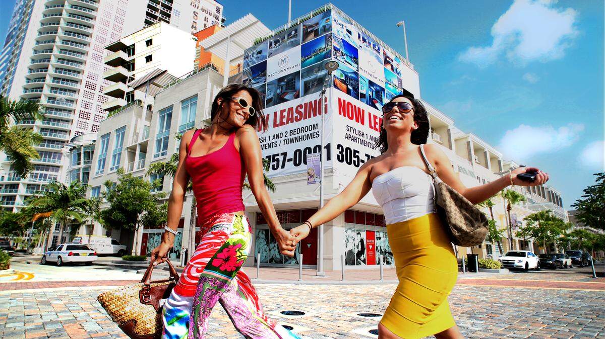 Michal Amedia and Sarah Weintraub walk across the street in Midtown, Miami.