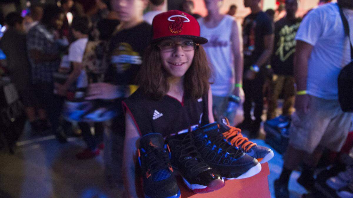 Daniel Golub, 12, a student at Walter C. Young Middle School, walks through the crowd with his trades at sneaker conference in Downtown Miami