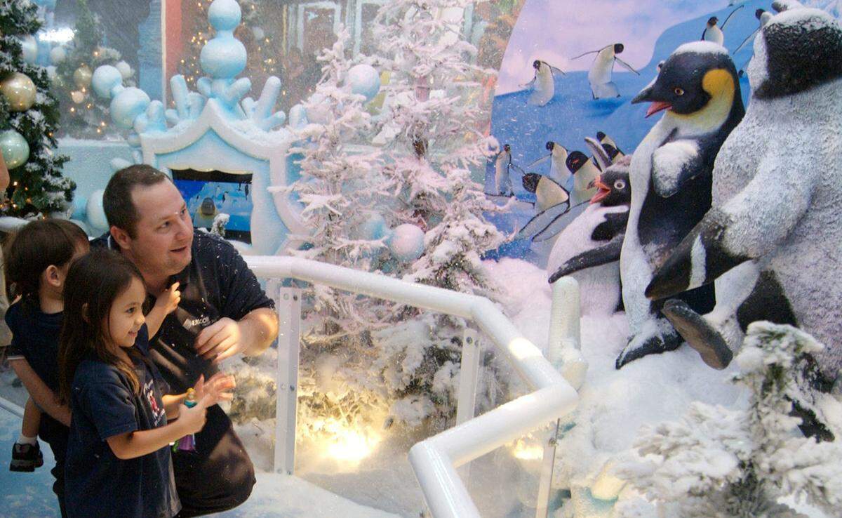 A family admires a Snow Globe display at Dolphin Mall in Doral.