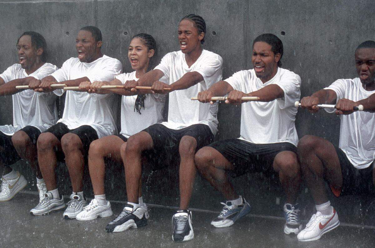 Devon (Nick Cannon, center), Diedre (Candace Carey, third from left) and the rest of teh show-style marching band drumline endure the rigors of training in "Drumline."