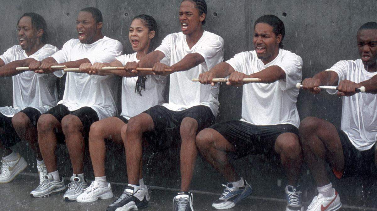 Devon (Nick Cannon, center), Diedre (Candace Carey, third from left) and the rest of teh show-style marching band drumline endure the rigors of training in "Drumline."