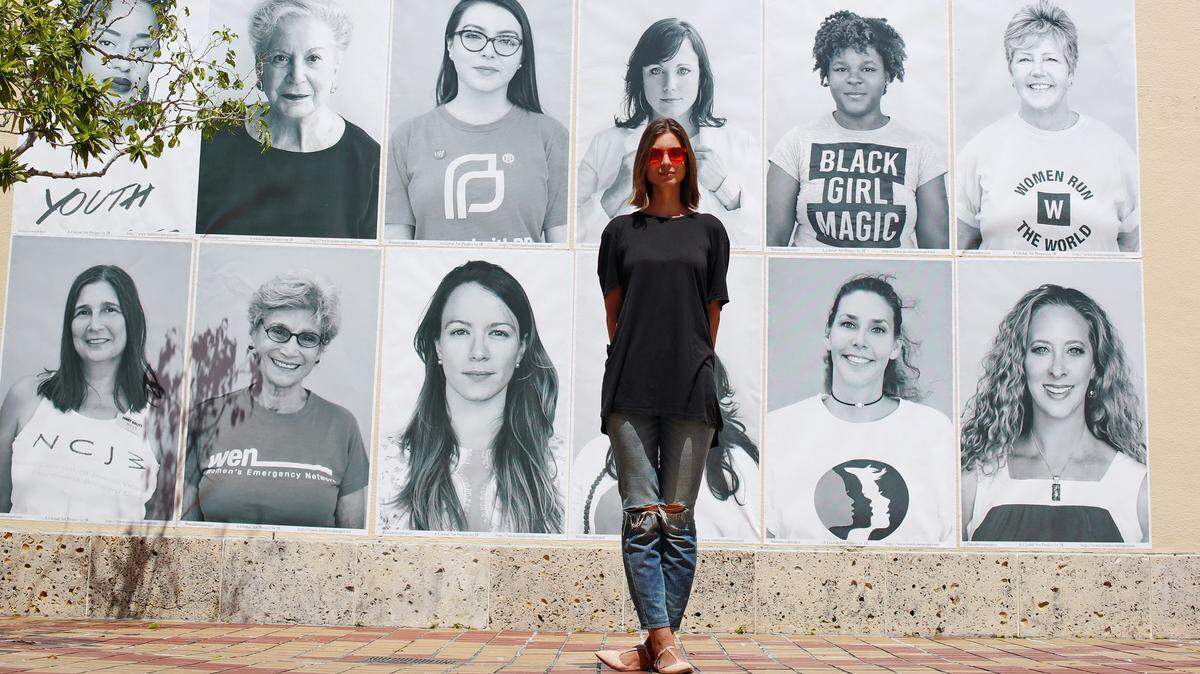 Photographer Ekaterina Jukowski stands in front of her photo collage of Miami Girls outside of HistoryMiami.