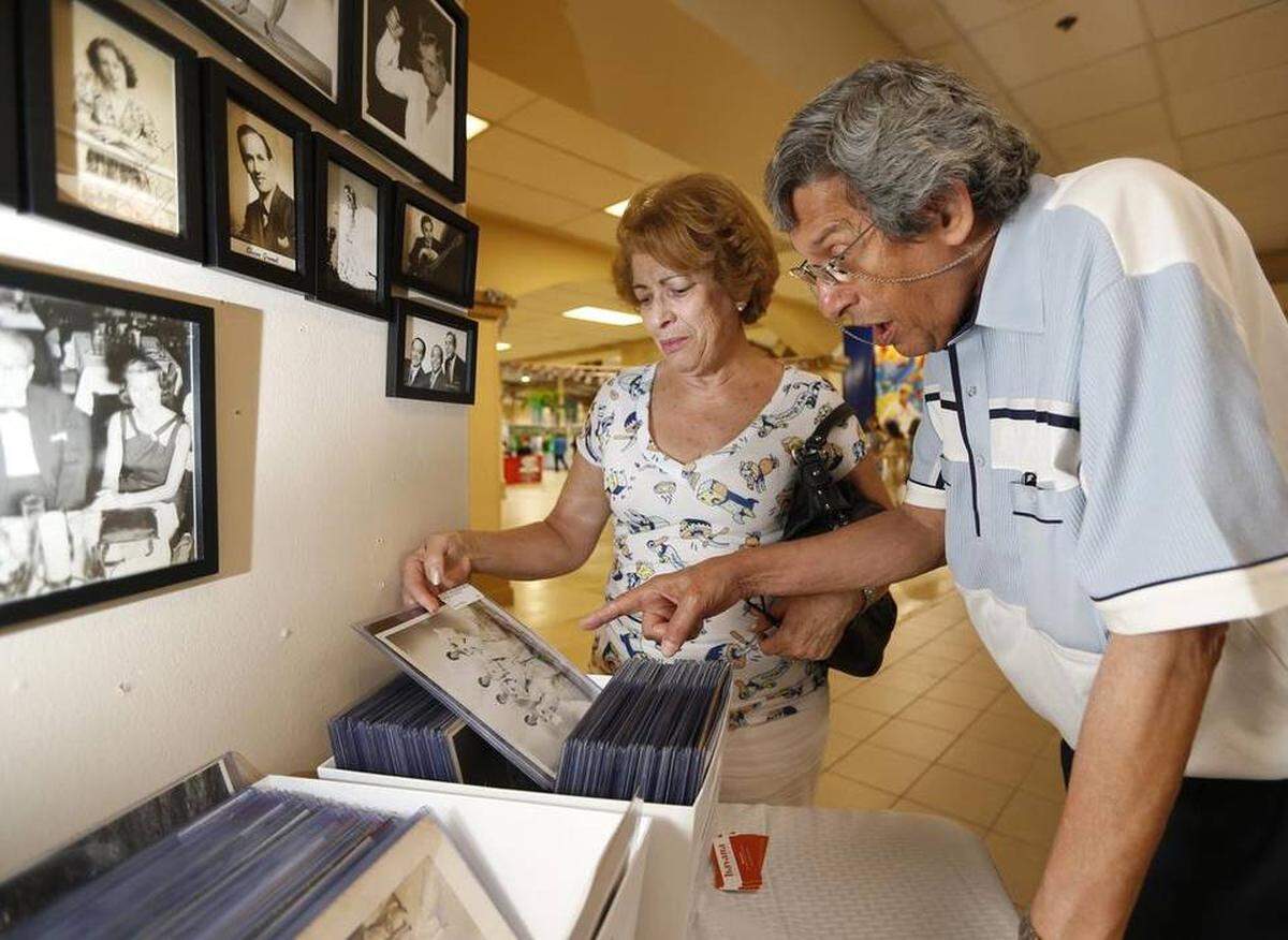 Meresa Ferez and Juan Barcena look through vintage photographs during the 17th annual Cuba Nostalgia at the Miami-Dade County Fair-Expo Center on Friday, May 15, 2015