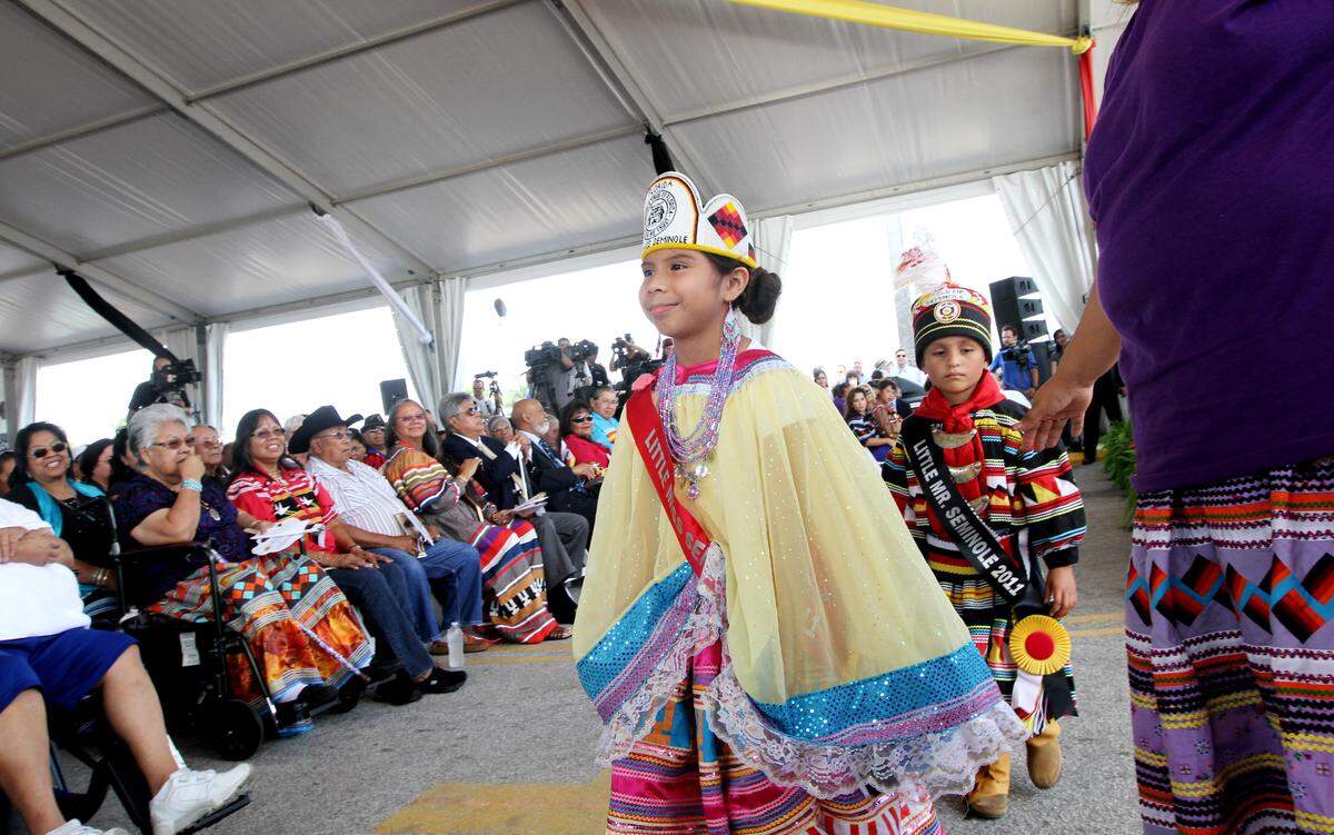 fl-tribe-inaugurationB -  Little Miss Seminole 2011 Brook Yescas, 8, (center) and Little Mr. Seminole 2011 Caleb Burton, 6, (back left) present themselves at the beginning of the Induction Ceremonies of Officials Under the Council Oak, which is located at the Seminole Classic casino just south of the Hard Rock on Monday, June 6,2011. The Seminole Tribe of Florida inducted several new Tribal Council members and Board of Directors under a packed tent. Read more about it in Nick Sortal's gambling blog at SunSentinel.com/action. Sarah Dussault, Sun Sentinel