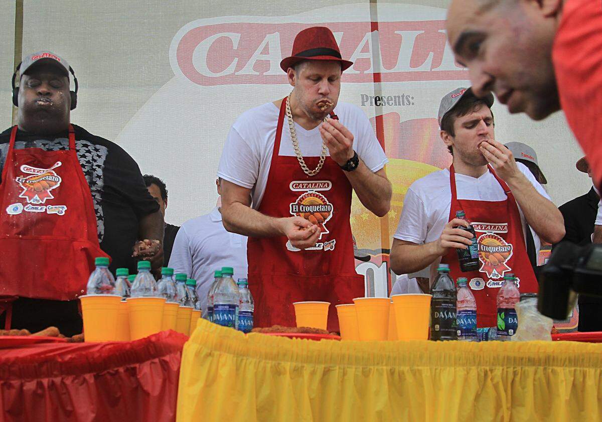 On Sunday March 12, 2017 it came down to the final minute as professional eaters Eric "Badlands" Booker, who won third place, Erik Denmark, center, try to out eat winner, Carmen Cincotti, right, during El Croquetazo competition at Calle Ocho presented by Catalina.