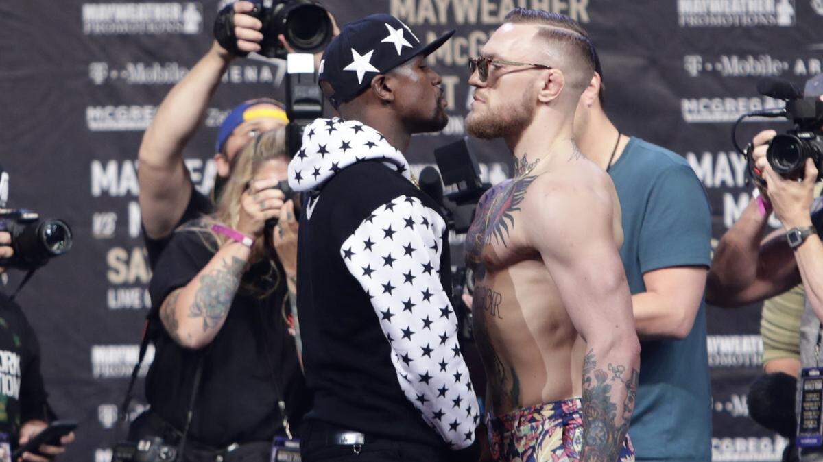 In this July 13, 2017, file photo, Floyd Mayweather Jr., left, and Conor McGregor, of Ireland, face each other for photos during a news conference at Barclays Center in New York. Nevada boxing regulators went out of their way to give a gift to both fighters, approving an exemption to the rule requiring 10-ounce gloves for the 154-pound fight so that both fighters can wear 8-ounce gloves. And just like that, the fight appeared more competitive–at least to some. (AP Photo/Frank Franklin II, File)