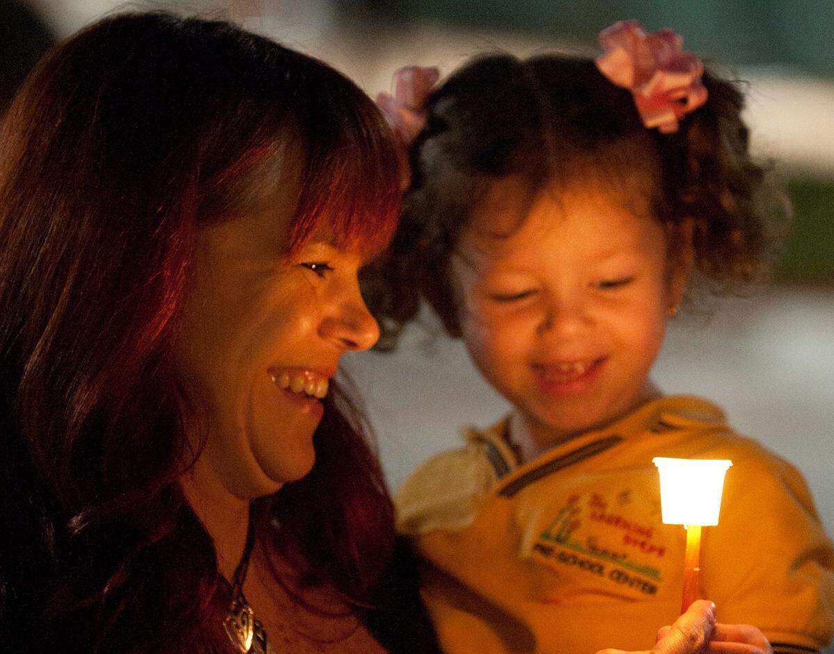 Doral residents Mary Priore and her daughter Bella Benlolo, 3, hold a candle during a menorah lighting ceremony in front of Doral City Hall, Wednesday, Dec. 4, 2013. About 100 people turned out for the free event, which was followed by singing, doughnuts, and other refreshments.