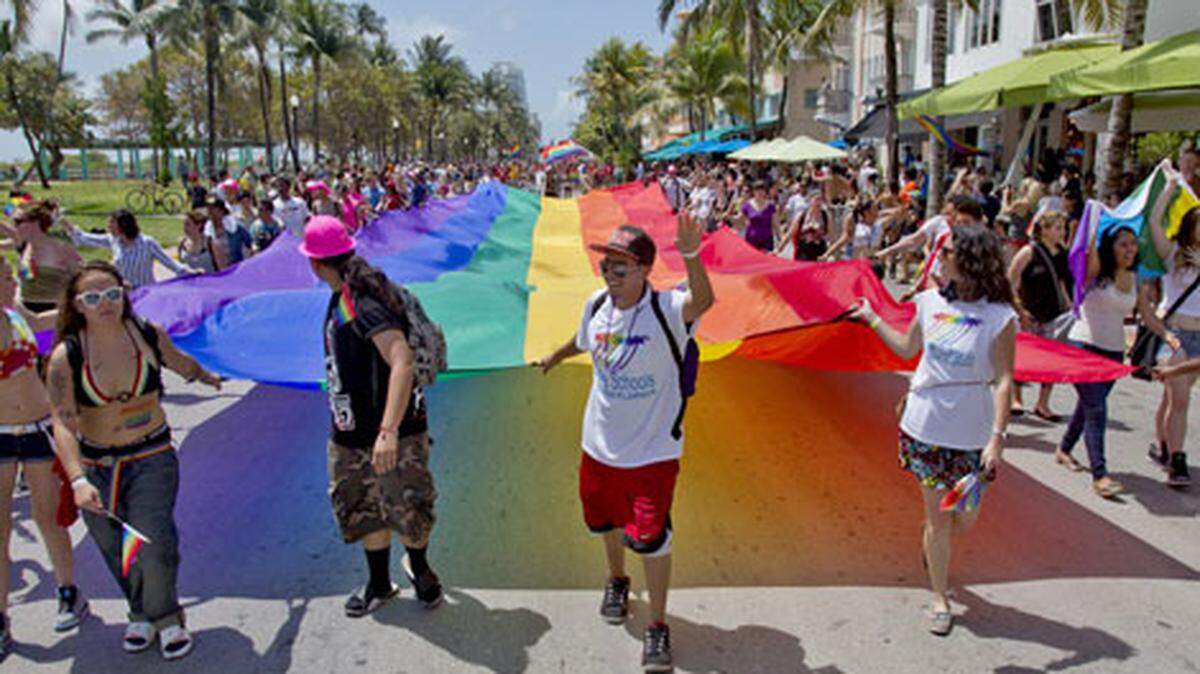 A group carries a gigantic rainbow flag during Miami Beach Gay Pride on Sunday April 14, 2013. Photo: Patrick Ferrell