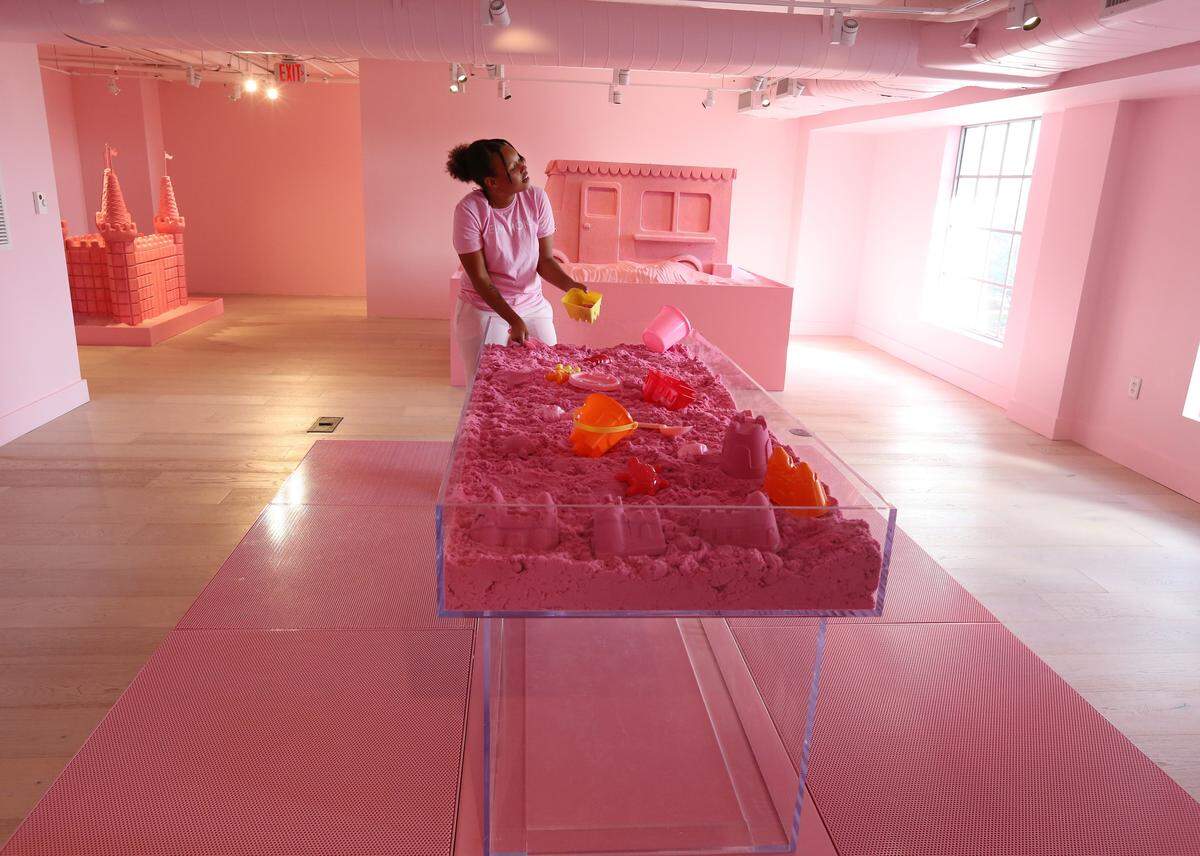 Kristina Jackson, A.K.A. Cookies and Kristina, sings and plays in the pink sand inside the sand castle room at The Museum of Ice Cream on Collins Ave. in Miami Beach. The museum offers guests the chance to taste, smell, swing and even swim in all things ice cream. (Emily Michot/Miami Herald)