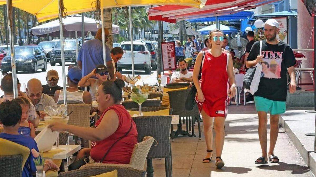 On a sunny Sunday, crowds enjoy drinks and meals on Ocean Drive. Sometimes the good feelings stop when the bill arrives.